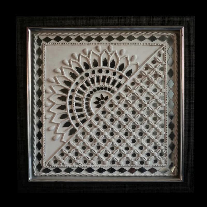 Handcrafted ivory Lippan art mural with geometric clay relief and small mirrors in a dark frame, representing traditional Indian mud and mirror work by Shree Jai Arts.