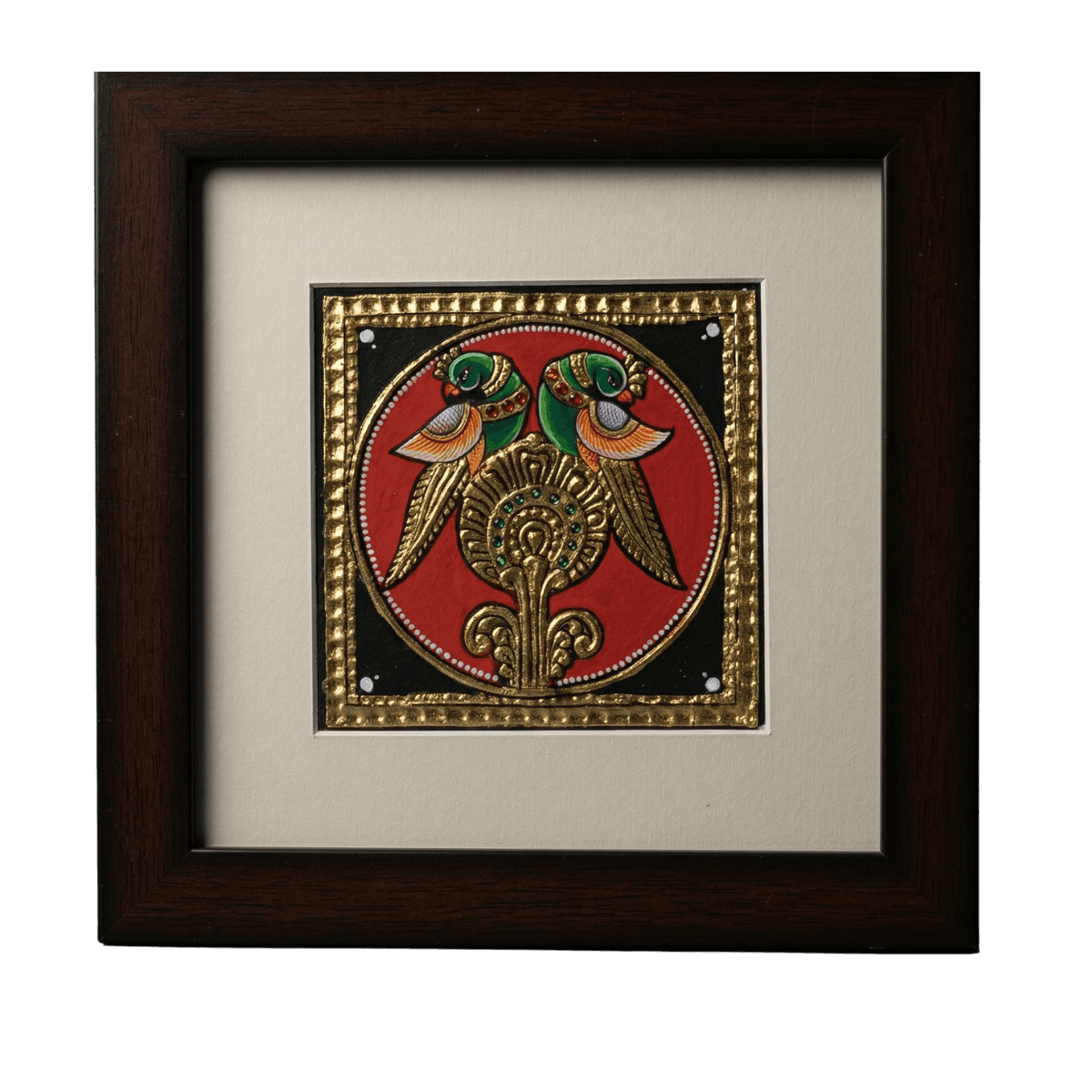 Hand-painted Tanjore painting of two green parrots perched on a golden pedestal within a circular frame, featuring 22K gold foil and kundan stones.