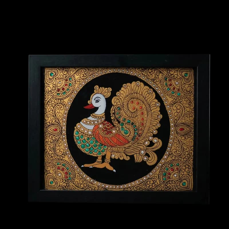 Handmade Annam (mythical swan) reverse glass painting by Shree Jai Arts. The sacred bird is depicted with vibrant green and red details, intricate gold jewelry, and surrounded by an ornate gold floral border against a black background, encased in a premium black frame.