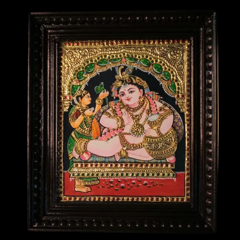 Hand-painted Tanjore painting of Butter Bala Krishna holding a butter pot and parrot, featuring 22K gold foil and kundan stones in a 3-inch teak wood frame.