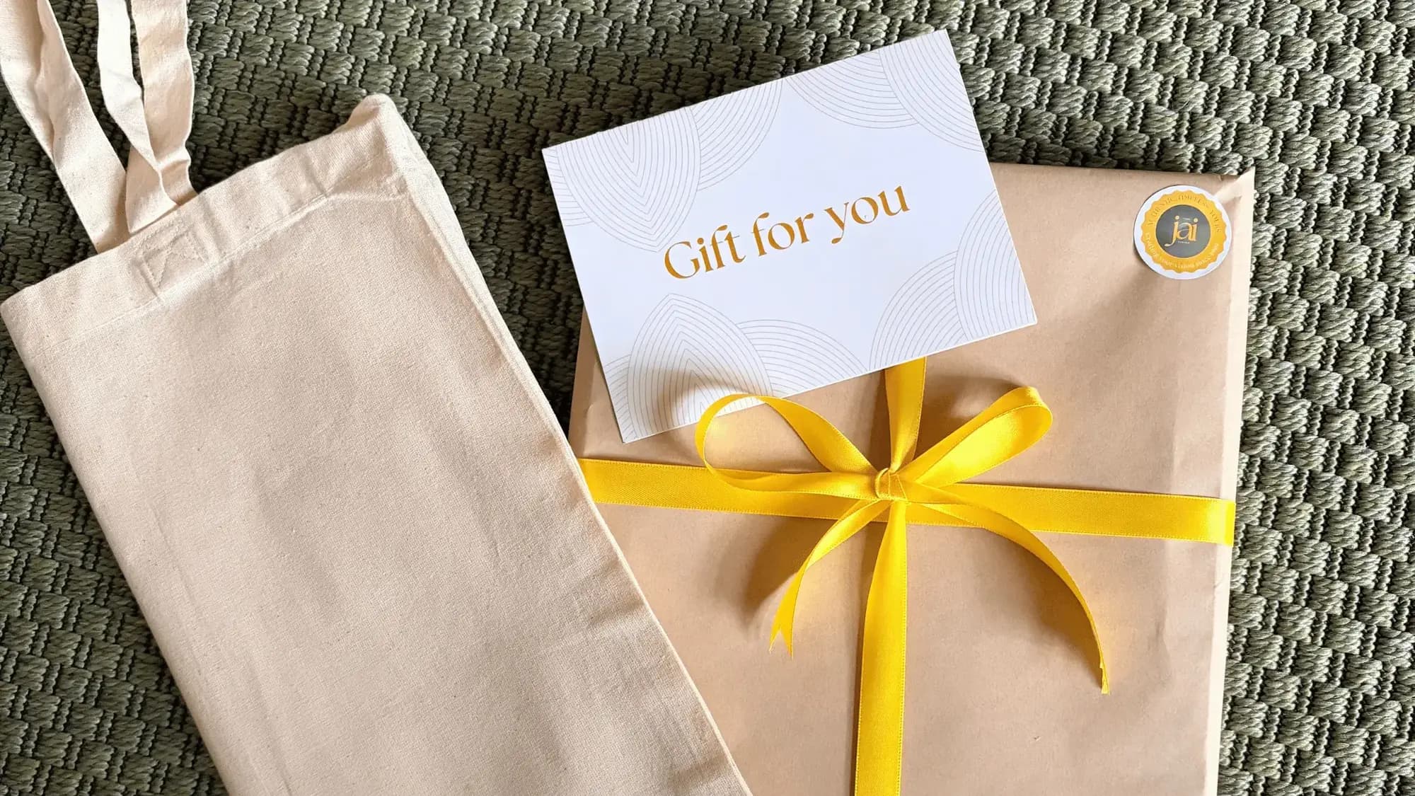 A Shree Jai Arts painting gift-wrapped in kraft paper with a yellow ribbon and a 'Gift for you' card